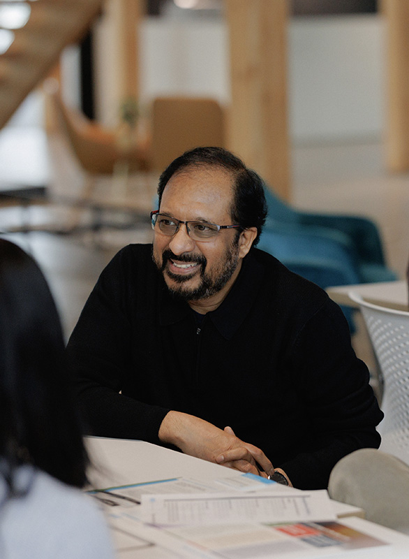 Uday smiling during a team meeting