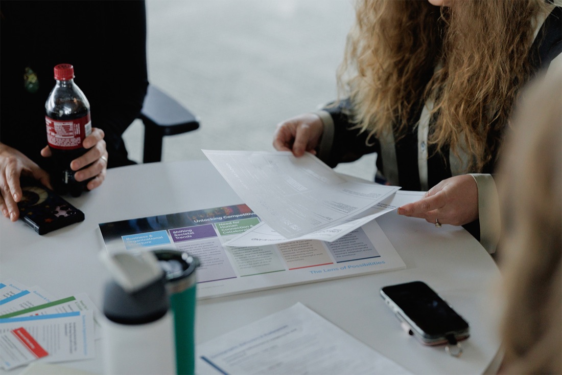 Colleagues reviewing printed program materials at a table
