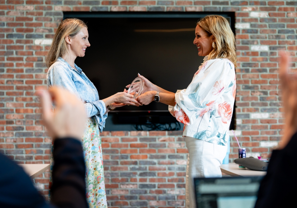 Top performer receiving an award as colleagues applaud