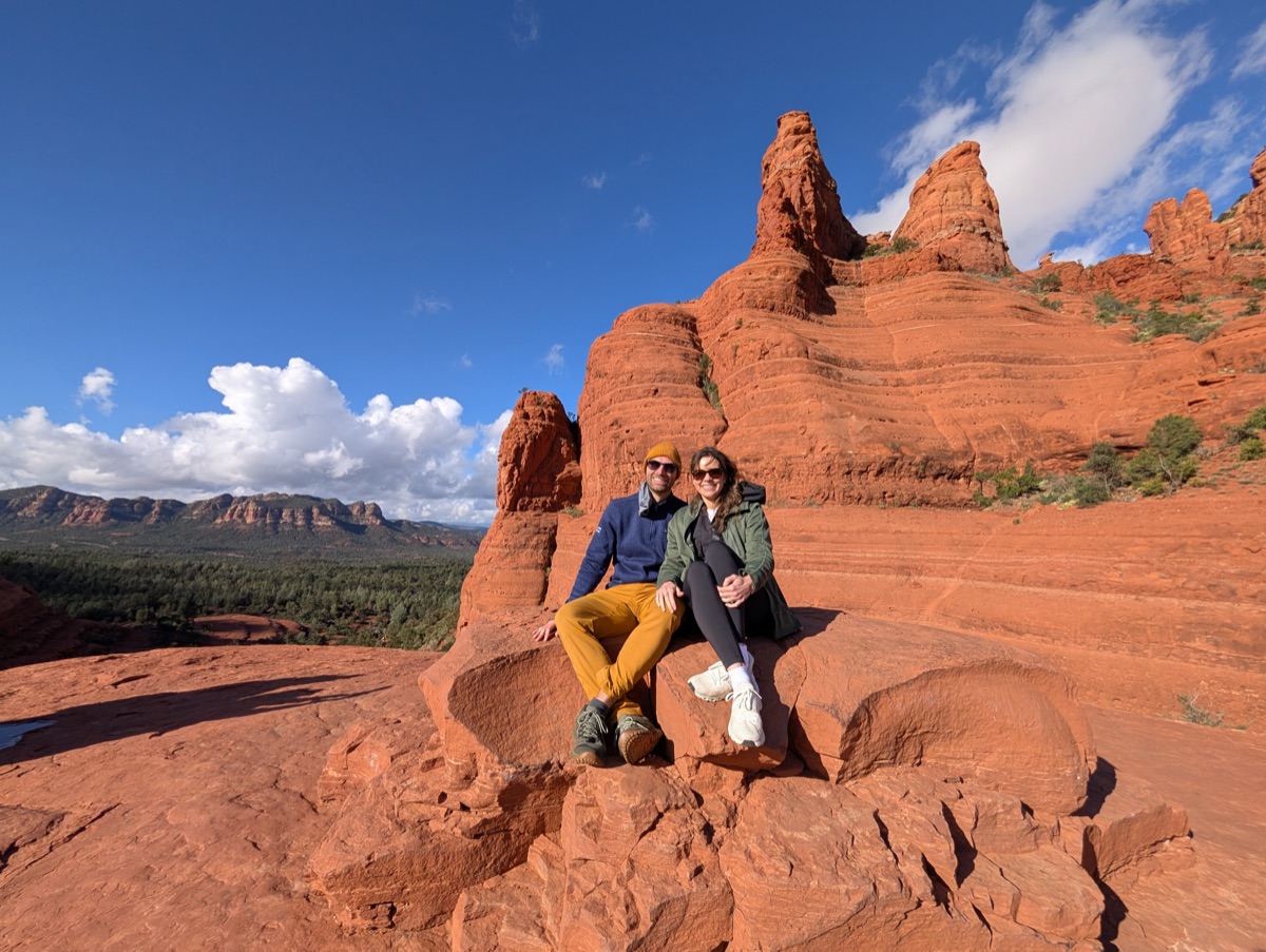 Couple sitting on red rock formations in the desert