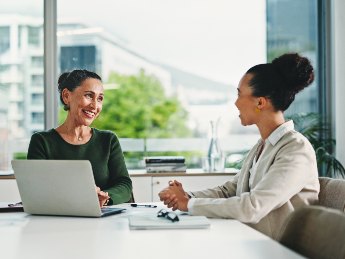 Two colleagues talking across a desk.